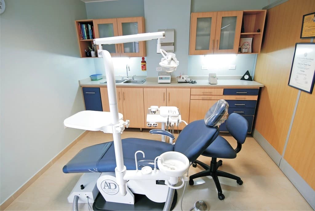 A clean, modern dental treatment room with a blue patient chair